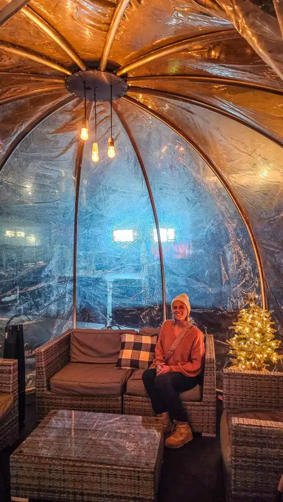woman sitting inside igloo at the rink