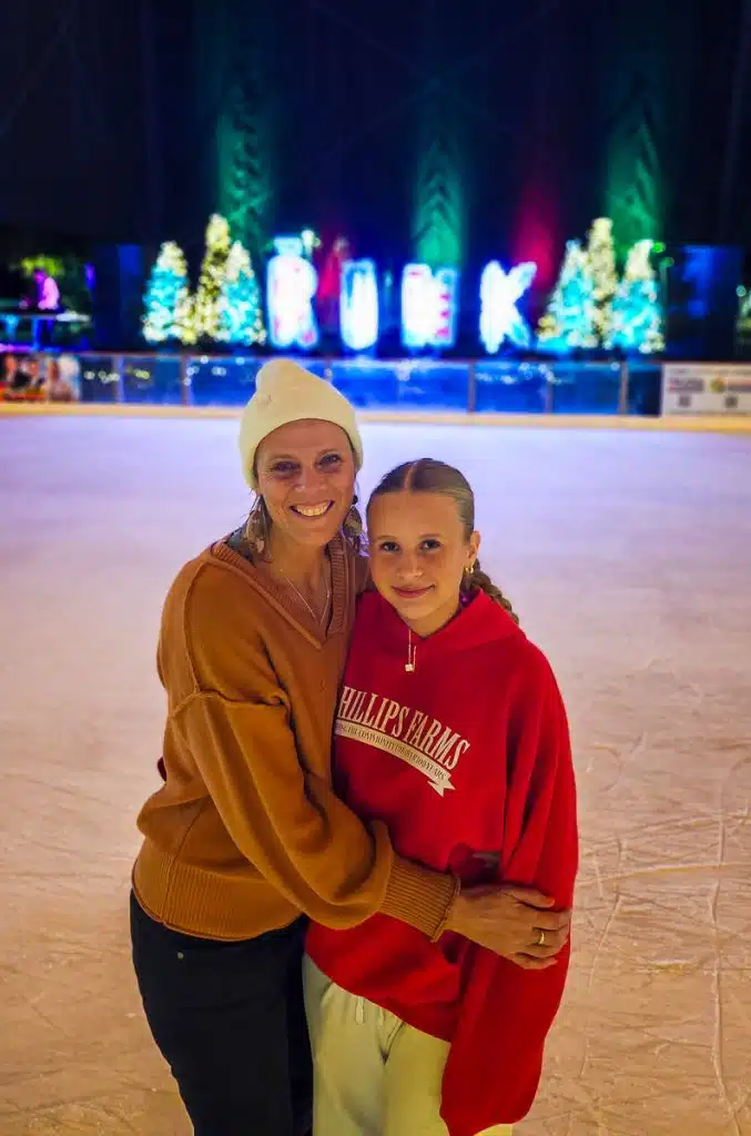 mother and daughter hugging on the ice skating rink