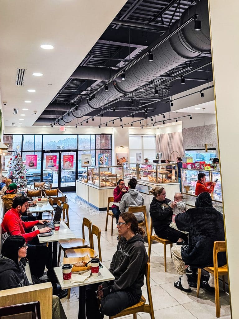 tables and chairs inside tous les jours filled with customers
