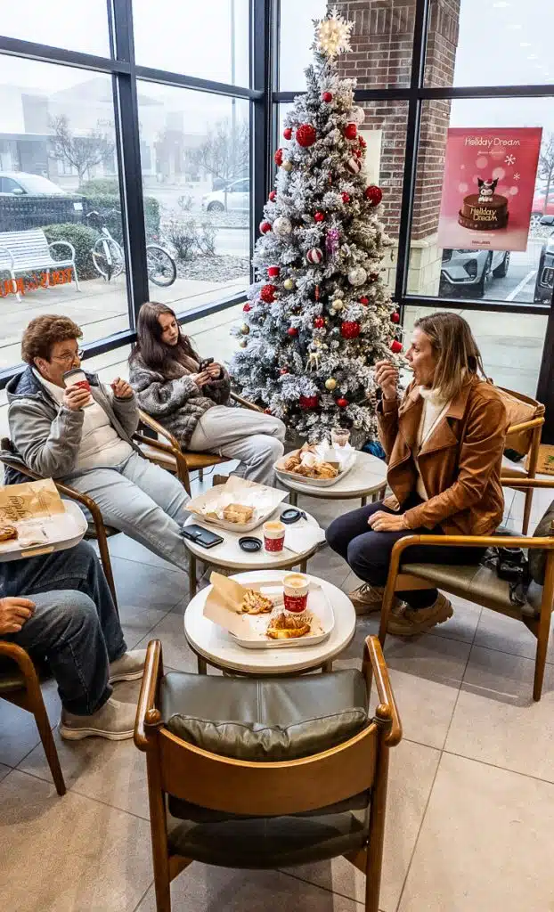 family sitting around christmas tree at tous les jours