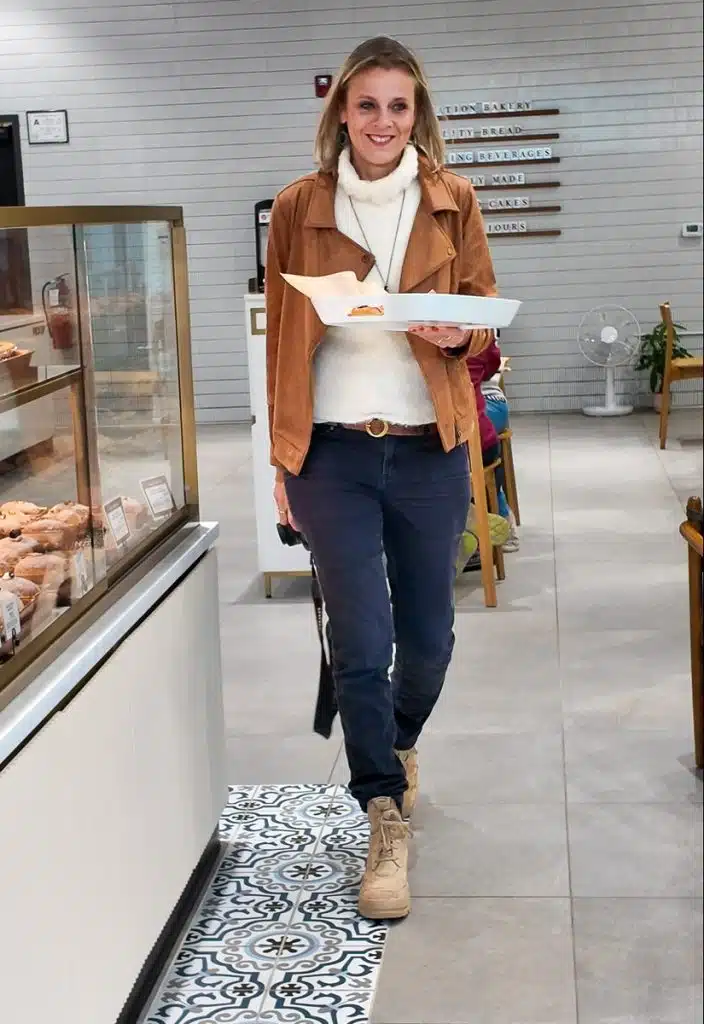 woman walking through tous les jours bakery with tray