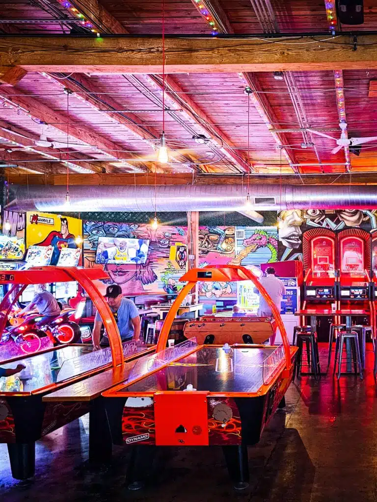 man playing arcade games inside boxcar raleigh
