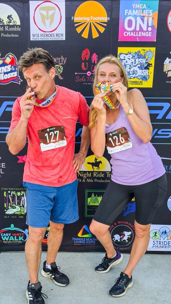 two racers biting their participation medals