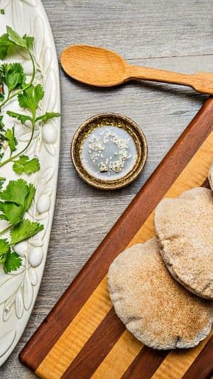 A wooden cutting board with bread on a table