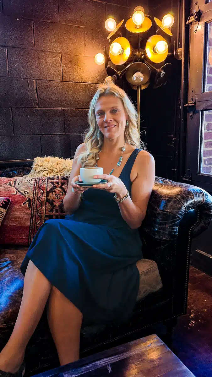 woman sitting on couch with coffee at crema and vine