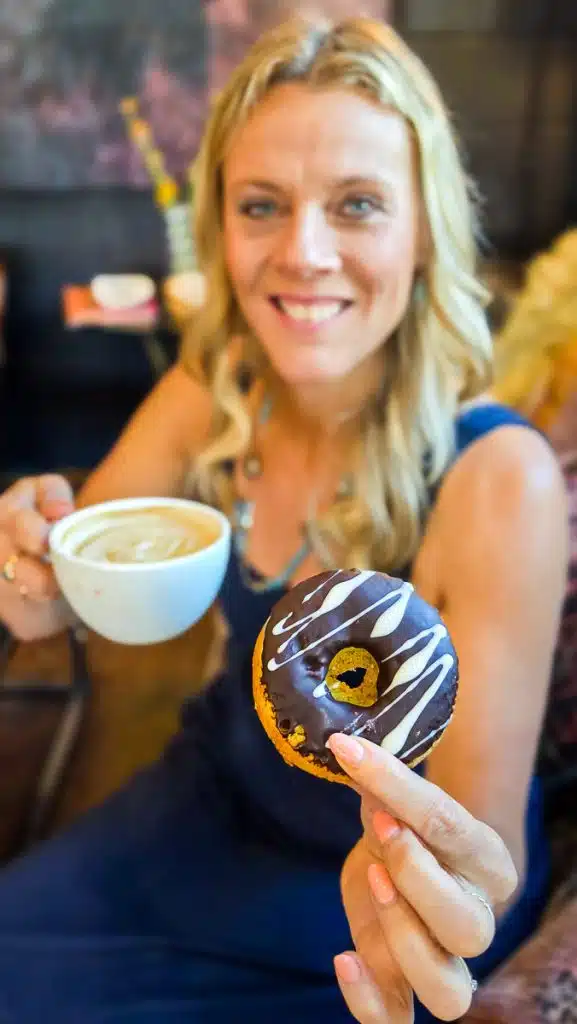 woman holding gluten free donut and coffee