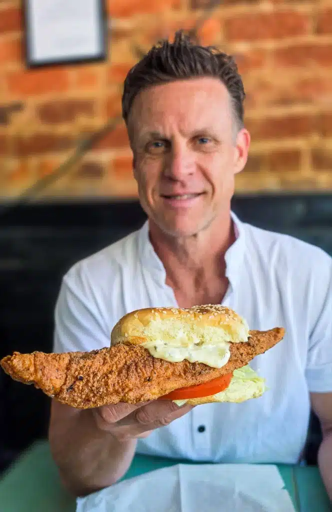 man holding fish sandwich