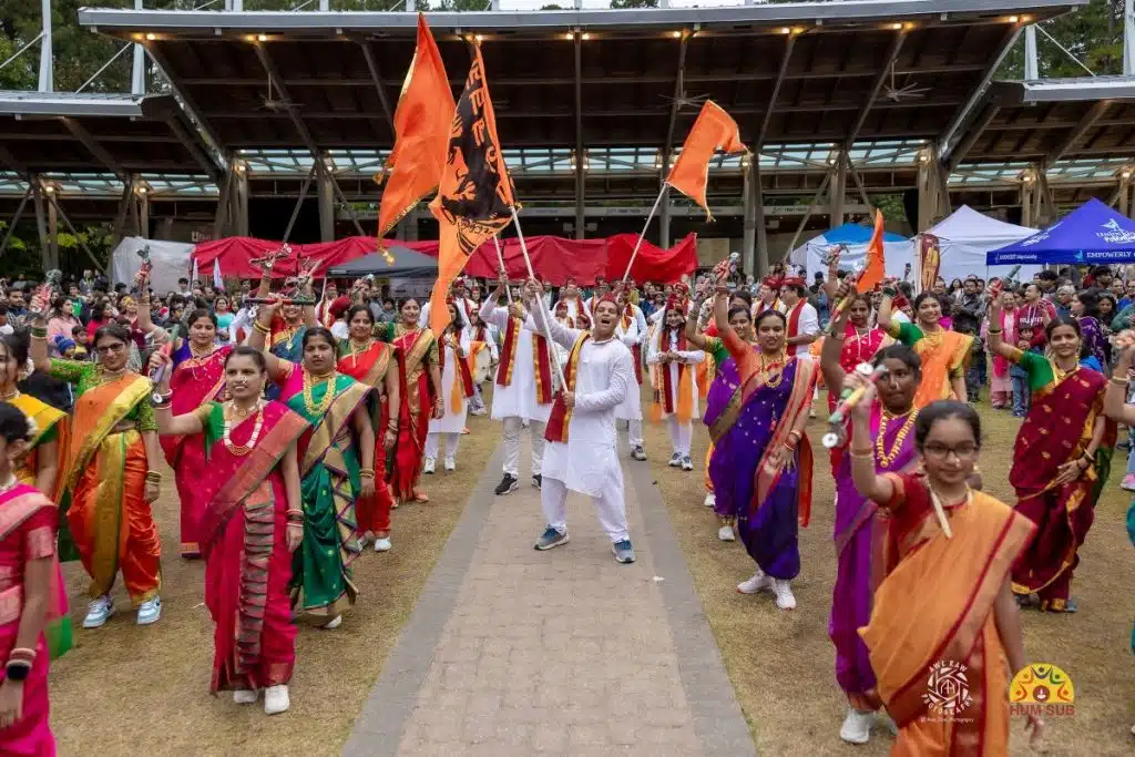 people in costume dancing and waving flags diwali cary