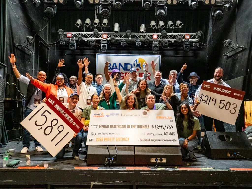 people on stage holding a check for band together